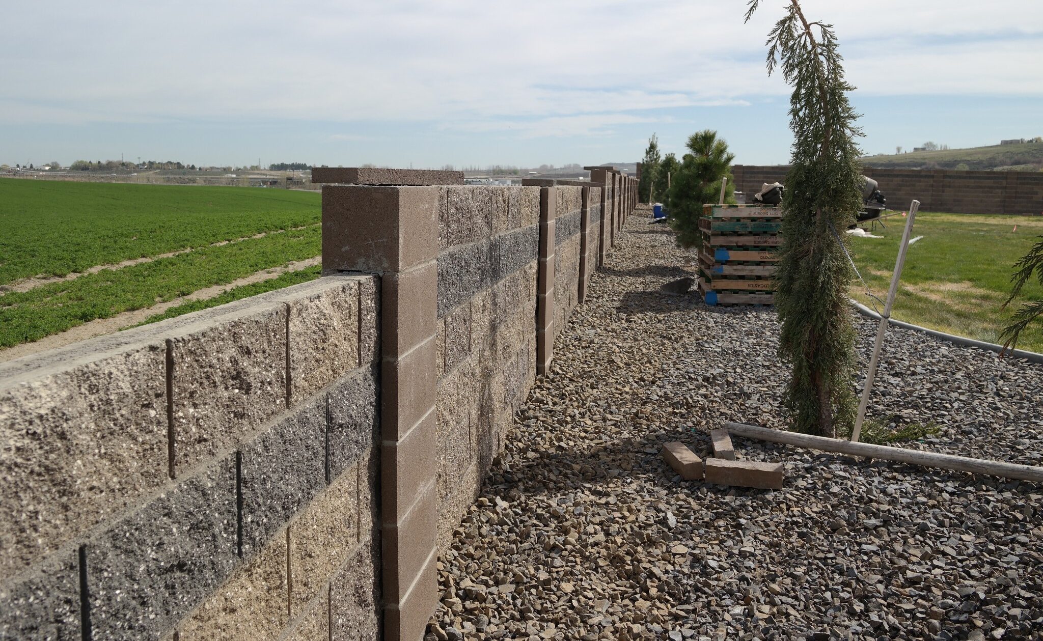 Long concrete block privacy fence along a backyard